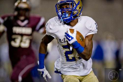 McEachern's  T.J. Rahming (21) is chased by Tucker's Chelo Lebon (35) as he runs the ball down the field on Friday, November 28, 2014.