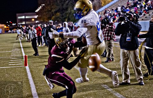 The ball slips through the fingers of McEachern's Malik McClary (80) as he is tackled in the end zone by Tucker's Akeam Peters (left) on Friday, November 28, 2014. 