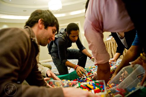 Aries Viera (center), Ryan Anshell and other competitors grab hand fulls of LEGOs during the LEGOLAND Discovery Center Atlanta's Brick Factor Competition at the Mandarin Oriental building in Atlanta on Sunday, November 23, 2014. 