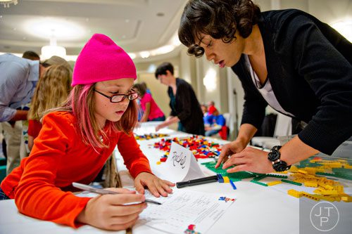 Gwyn Balman (left) takes notes as she talks to Rachel Towns while she builds a scultpure using LEGOs during the LEGOLAND Discovery Center Atlanta's Brick Factor Competition at the Mandarin Oriental building in Atlanta on Sunday, November 23, 2014. 