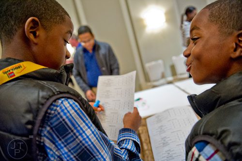 Carlos Gilbert (left) and his brother Caleb compare notes as they judge Daryl Wilcher as he builds a sculpture from the movie "Elf" using LEGOs during the LEGOLAND Discovery Center Atlanta's Brick Factor Competition at the Mandarin Oriental building in Atlanta on Sunday, November 23, 2014.