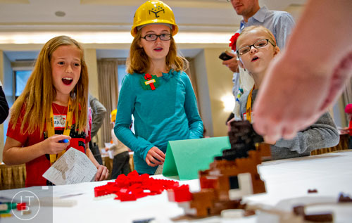 Reese Black (left), Madeline Mrozek and Lily Carnell watch as Kate Lawter builds a Rudolph the Red Nosed Reindeer sculpture using LEGOs during the LEGOLAND Discovery Center Atlanta's Brick Factor Competition at the Mandarin Oriental building in Atlanta on Sunday, November 23, 2014. 