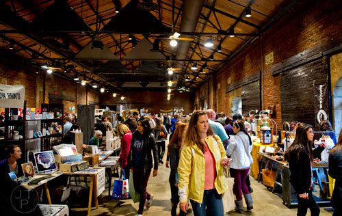 Kara Smith (center) walks the rows of artist booths during the 10th annual Indie Craft Experience Holiday Shopping Spectacular at the Georgia Freight Depot in Atlanta on Sunday, November 23, 2014. 