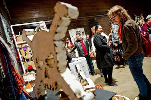 Angela Parker looks over the Kiwi Vintage booth during the 10th annual Indie Craft Experience Holiday Shopping Spectacular at the Georgia Freight Depot in Atlanta on Sunday, November 23, 2014. 