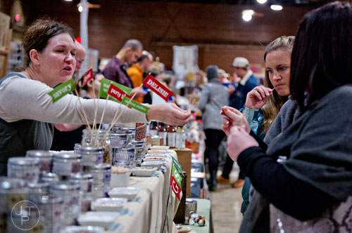 Beautiful Briny Sea owner Suzi Sheffield (left) talks to Katie Watt and Morgan Boggs as they taste her flavored salts during the 10th annual Indie Craft Experience Holiday Shopping Spectacular at the Georgia Freight Depot in Atlanta on Sunday, November 23, 2014.