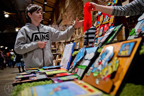 Harry Ferguson (left) reaches for his newly bought magnet at the Red Rocket Farm booth during the 10th annual Indie Craft Experience Holiday Shopping Spectacular at the Georgia Freight Depot in Atlanta on Sunday, November 23, 2014. 