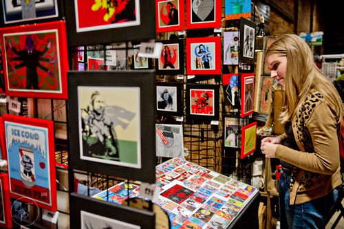 Allison Morway (right) looks at the artwork in the Belligerent Monkey booth during the 10th annual Indie Craft Experience Holiday Shopping Spectacular at the Georgia Freight Depot in Atlanta on Sunday, November 23, 2014. 
