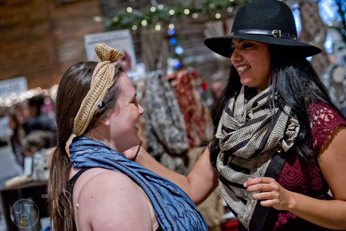 Rachel Bullard (left) gets help putting on a hair wrap from Maelu booth owner Meghna Dave during the 10th annual Indie Craft Experience Holiday Shopping Spectacular at the Georgia Freight Depot in Atlanta on Sunday, November 23, 2014. 
