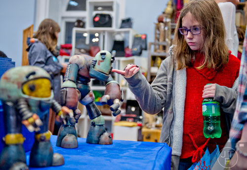 Elizabeth Maciejewski (right) checks out the sculptures at the Klapthor's Universal Robots booth during the 10th annual Indie Craft Experience Holiday Shopping Spectacular at the Georgia Freight Depot in Atlanta on Sunday, November 23, 2014.