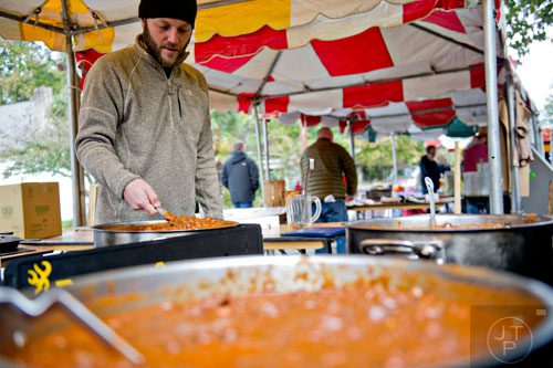 Jeremiah Weston stirs vats of chili during the 12th annual Cabbagetown Chomp & Stomp in Atlanta on Saturday, November 1, 2014. 