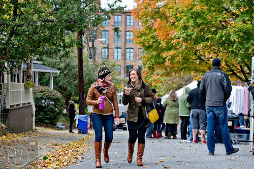 Kelly Coffman (left) walks through the artist market with her sister Caitlin Erwin during the 12th annual Cabbagetown Chomp & Stomp in Atlanta on Saturday, November 1, 2014. 