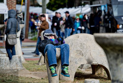 Lindsay Smith (center) lays on the stone sculpture in Cabbagetown Park during the 12th annual Cabbagetown Chomp & Stomp in Atlanta on Saturday, November 1, 2014. 