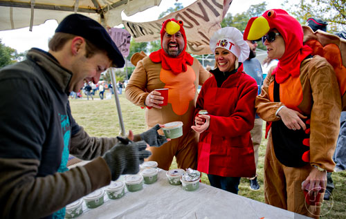 Jessica Sherrill (right), Kimberly Odum and Sean Martin turn in their chili entry to Chris McCain during the 12th annual Cabbagetown Chomp & Stomp in Atlanta on Saturday, November 1, 2014. 