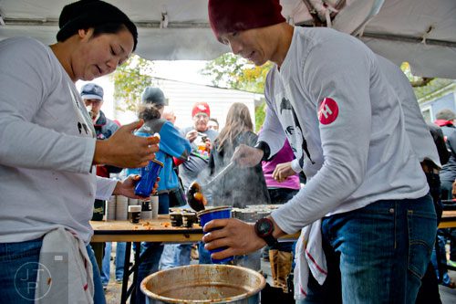 Beth Yeckley (left) and Dale Kim scoop out cups of chili during the 12th annual Cabbagetown Chomp & Stomp in Atlanta on Saturday, November 1, 2014. 