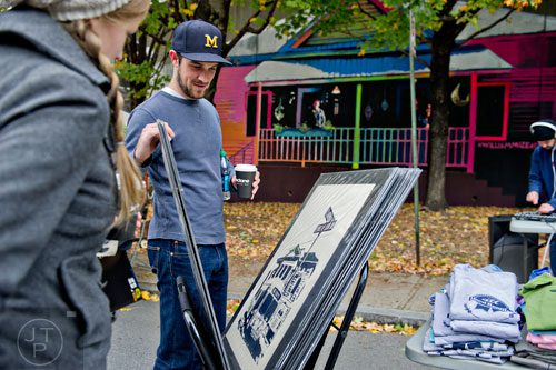 Kristi Cordes (left) and Eric Hall look at artwork during the 12th annual Cabbagetown Chomp & Stomp in Atlanta on Saturday, November 1, 2014. 