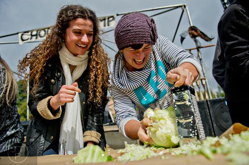 Emma Thibaudeau (left) cheers on Jess Peterick as she shreds cabbage in a competition during the 12th annual Cabbagetown Chomp & Stomp in Atlanta on Saturday, November 1, 2014. 