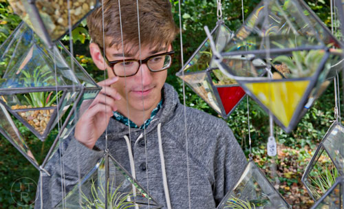 Dylan Moss looks at the glass planters in Dan Taylor's booth during the Chastain Park Art Festival in Atlanta on Sunday, November 2, 2014. 