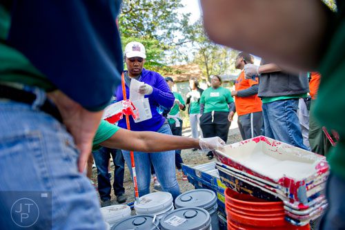 Leah Carter (center) grabs supplies to help clean up the Jett St. Apartments in Atlanta on Tuesday, November 4, 2014. 