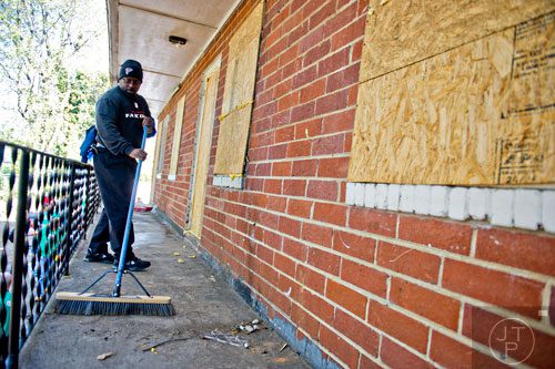 Reggie Childs sweeps debris off of the second floor walkway at the Jett St. Apartments in Atlanta on Tuesday, November 4, 2014. 