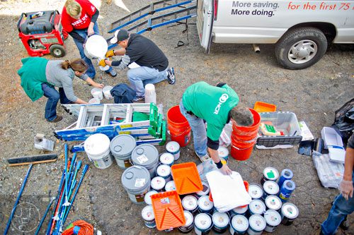 Celeste Provost (left), Debbie Knowlan and John Russo pour paint into buckets at the Jett St. Apartments in Atlanta on Tuesday, November 4, 2014. 