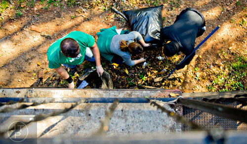 Volunteers scoop trash into bags as the help clean up the Jett Street Apartments in Atlanta on Tuesday, November 4, 2014.