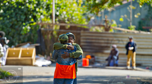 Tavaris Waller (right) hugs Juanita Wallace as she takes a break from cleaning up the Jett St. Apartments in Atlanta on Tuesday, November 4, 2014. 