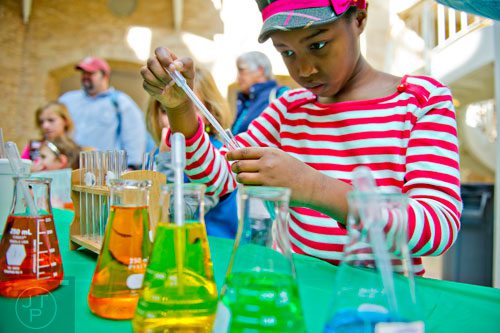 Grace Njagi explores the density of liquids during Science at Hand at the Fernbank Museum of Natural History in Atlanta on Saturday, November 8, 2014. 