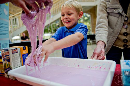 Gabriel Williams (right) plays with non-newtonian fluid as Aaron McKee drips some on his hands during Science at Hand at the Fernbank Museum of Natural History in Atlanta on Saturday, November 8, 2014. 