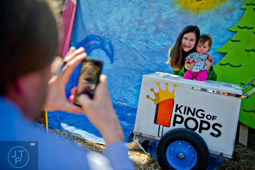 Elizabeth Fox (center) holds her daughter Frances as her husband Chris takes a photo during the 4th annual King of Pops Field Day at The Masquerade in Atlanta on Saturday, November 8, 2014. 