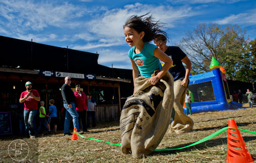 Eva Wong (center) beats David Walton to the finish line in a sack race during the 4th annual King of Pops Field Day at The Masquerade in Atlanta on Saturday, November 8, 2014. 