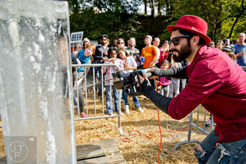 Adrian Barzaga (right) sculpts a block of ice into a unicorn using a chainsaw during the 4th annual King of Pops Field Day at The Masquerade in Atlanta on Saturday, November 8, 2014.