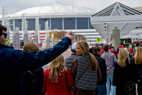 Marie Mattox (right) walks towards the Georgia Dome in Atlanta with thousands of other people to watch the Chick-fil-A Peach Bowl on Wednesday, December 31, 2014. 