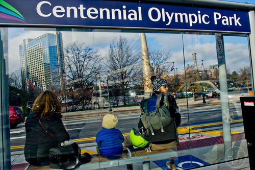 Ivy Way (left), her son A.G. and Carl Holt wait for an Atlanta Streetcar at the Centinnial Olympic Park stop on Wednesday, December 31, 2014. 