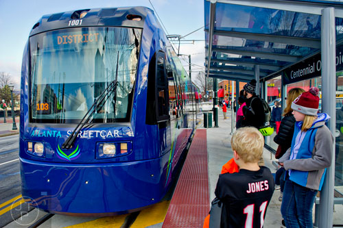 Shelby Jones (right) and her brother Dalton wait at the Centennial Olympic Park stop as an Atlanta Streetcar pulls up on Wednesday, December 31, 2014. 