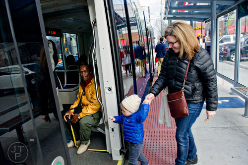 Ivy Way (right) holds her son A.G.'s hand as they climb aboard an Atlanta Streetcar at Centinnial Olympic Park on Wednesday, December 31, 2014. 