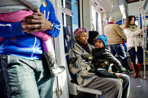 Yohai Yisrael (center) sits in his aunt Angelyn Love's lap as people board the Atlanta Streetcar on Wednesday, December 31, 2014. 