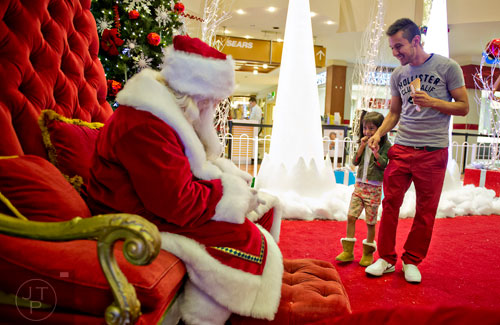 Uriel Diaz (right) holds his daughter Jessica's hand as they visit with Santa at Town Center at Cobb in Kennesaw on Sunday, November 30, 2014. 