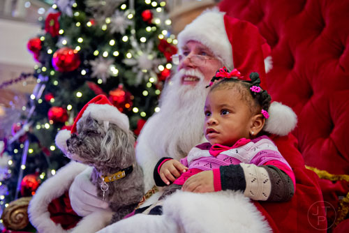 Camille Harris (right) and her shih tzu Chewi take a photo with Santa at Town Center at Cobb in Kennesaw on Sunday, November 30, 2014. 