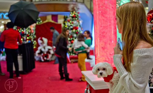 Madison Holbert (right) holds her maltese Marley as she waits for a photo with Santa at Town Center at Cobb in Kennesaw on Sunday, November 30, 2014. 