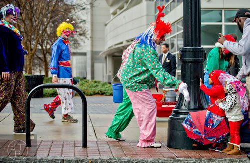 Azaryah Peoples (right) and her brother Ayden give high fives to a clown before the start of the 2014 Children's Christmas Parade in Atlanta on Saturday, December 6, 2014. 
