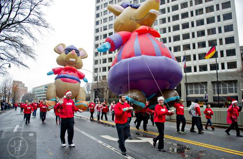 Ethan Davis (center) guides a mouse balloon down Peachtree St. during the 2014 Children's Christmas Parade in Atlanta on Saturday, December 6, 2014. 