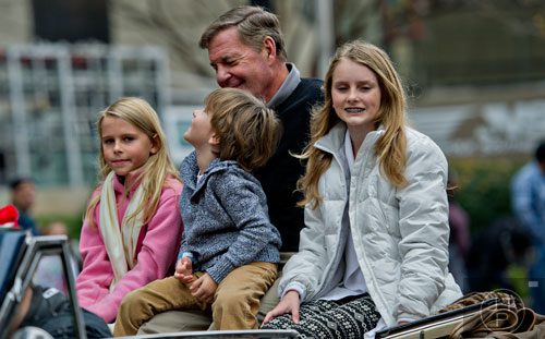 Glenn Burns (center) rides down Peachtree St. with his grandchildren Olivia (left), Lucas and Lilly Nielsen during the 2014 Children's Christmas Parade in Atlanta on Saturday, December 6, 2014. 