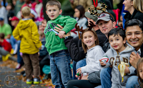 Dewayne Joy (right) holds his daughter Emma as they watch floats and bands pass by during the 2014 Children's Christmas Parade in Atlanta on Saturday, December 6, 2014. 