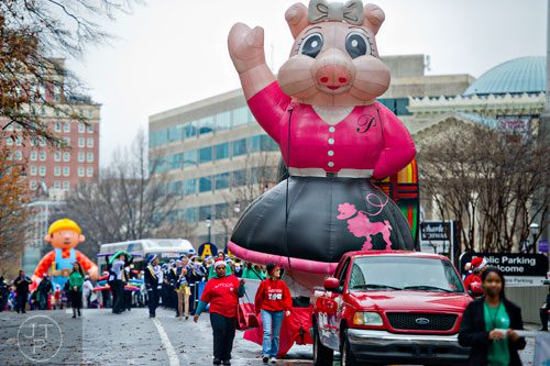A balloon of Priscilla the Pink Pig is driven down Peachtree St. during the 2014 Children's Christmas Parade in Atlanta on Saturday, December 6, 2014.