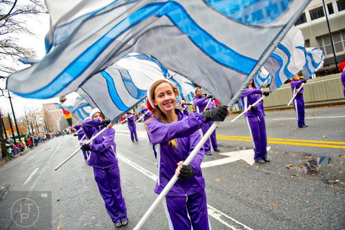Megan Mallari (center) twirls her flag with the Hiram High School band as they march down Peachtree St. during the 2014 Children's Christmas Parade in Atlanta on Saturday, December 6, 2014. 