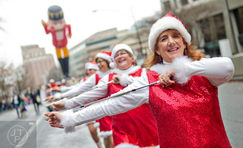 Jamie Thomas (right) dances down Peachtree St. during the 2014 Children's Christmas Parade in Atlanta on Saturday, December 6, 2014. 