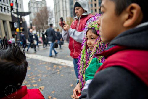 Ariana Victoria (center) watches floats and bands pass by with her father Octavio and brother Mariano during the 2014 Children's Christmas Parade in Atlanta on Saturday, December 6, 2014. 