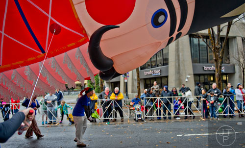Matt Williams (center) guides a nutcracker balloon down Peachtree St. during the 2014 Children's Christmas Parade in Atlanta on Saturday, December 6, 2014.