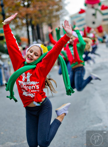 Lillian Trippe leaps into the air as she dances down Peachtree St. during the 2014 Children's Christmas Parade in Atlanta on Saturday, December 6, 2014. 