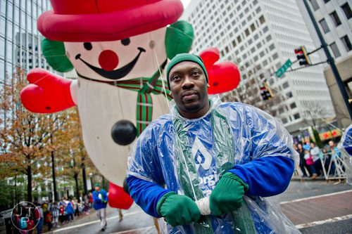 Patrick Clayborne (center) guides a Frosty the Snowman balloon down Peachtree St. during the 2014 Children's Christmas Parade in Atlanta on Saturday, December 6, 2014. 